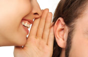 woman whispering in someone's ear